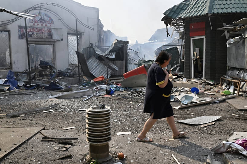 Женщина проходит мимо разрушенного рынка в Славянске