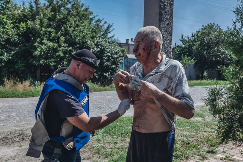 Сотрудник экстренных служб оказывает помощь раненому после обстрела в Бахмуте Донецкой области