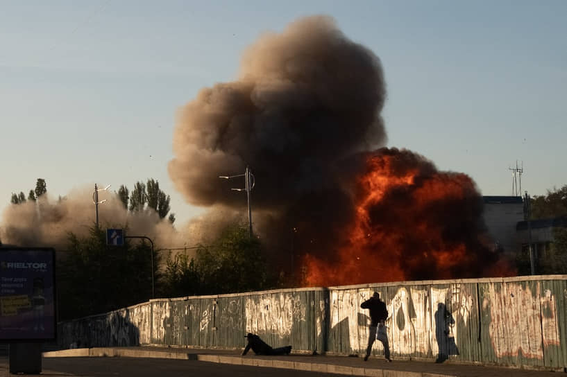 Прохожие в Киеве на фоне взрыва, произошедшего в результате атаки беспилотника