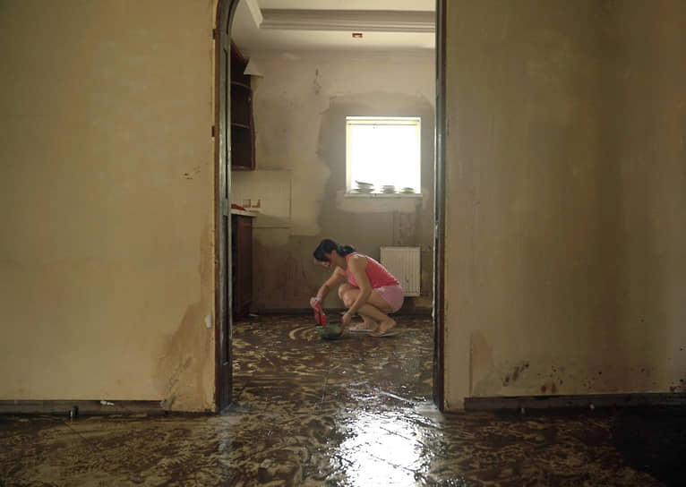 Жительница Херсона убирает в квартире последствия прорыва плотины Каховской ГЭС