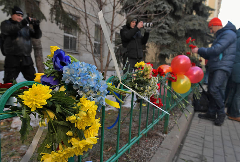 Люди возлагают цветы к посольству Украины в России