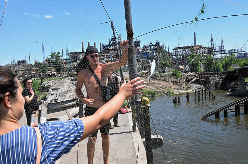 Жители Мариуполя ловят рыбу с разрушенного моста напротив металлургического комбината «Азовсталь»