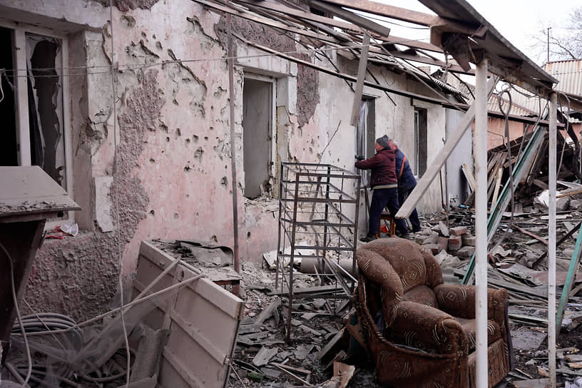 Мужчины возле разрушенного дома в Донецке