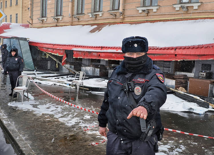 Сотрудник полиции стоит рядом с кафе на Университетской набережной в Санкт-Петербурге, в котором при взрыве погиб военкор Владлен Татарский