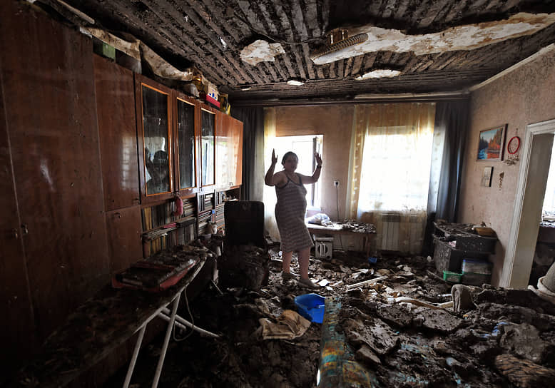 Жительница Донецка стоит в доме, пострадавшем от обстрела