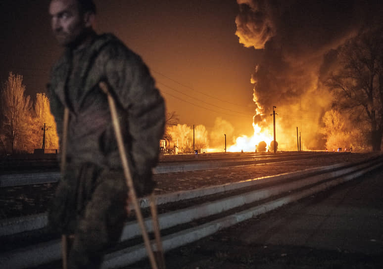 Человек на фоне пожара, начавшегося после обстрела станции Мушкетово в Донецке