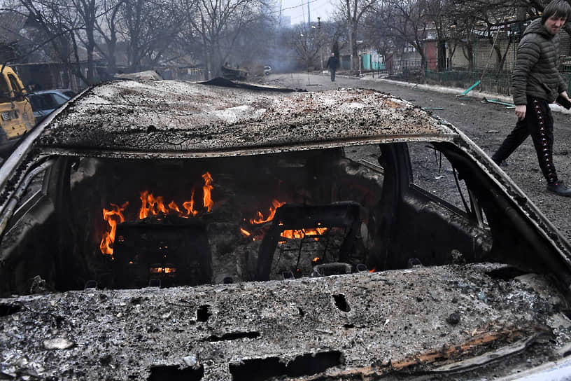 Горящая машина после обстрела в Донецке