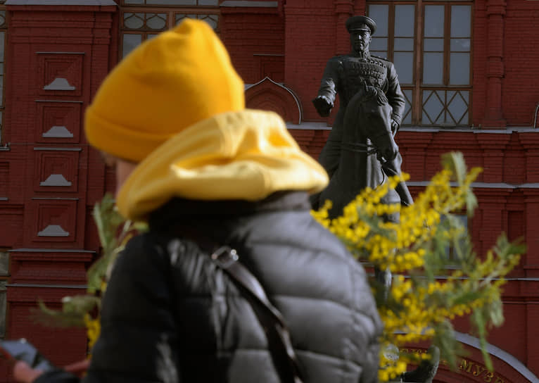 Женщина с букетом мимозы на Манежной площади в Москве