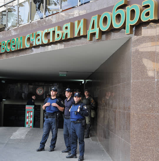 Сотрудники национальной полиции Украины в бронежилетах перед зданием с надписью «всем счастья и добра» в Одессе