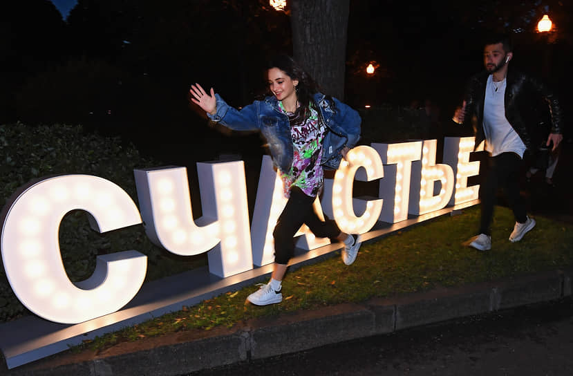 Выпускники 2020 года пробегают мимо надписи «Счастье» в парке им. Горького в Москве