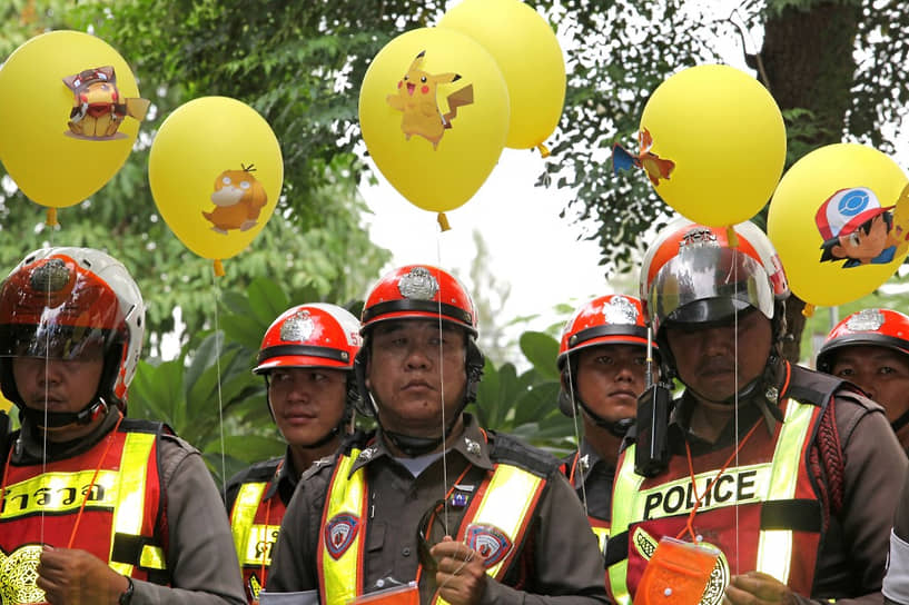 Полицейские держат воздушные шары с изображениями покемонов в рамках компании против водителей, игравших в Pokemon Go на улицах Бангкока 