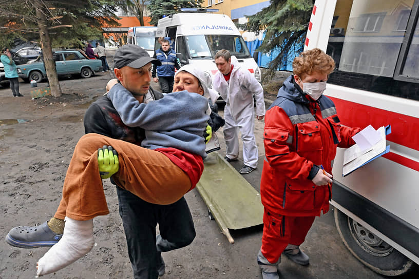 Мариуполь. Мужчина помогает донести женщину в больницу