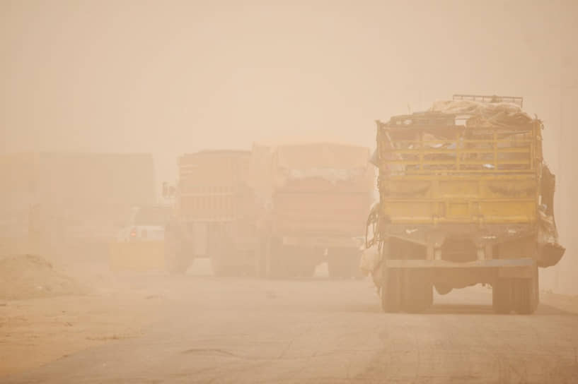 Грузовики едут сквозь песчаную бурю в городе Насирия