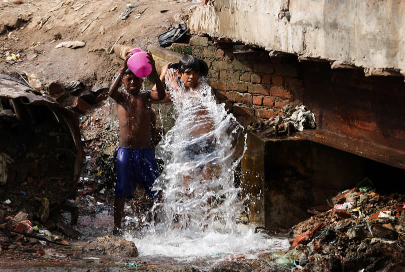 Нью-Дели, Индия. Дети охлаждаются под струей проточной воды