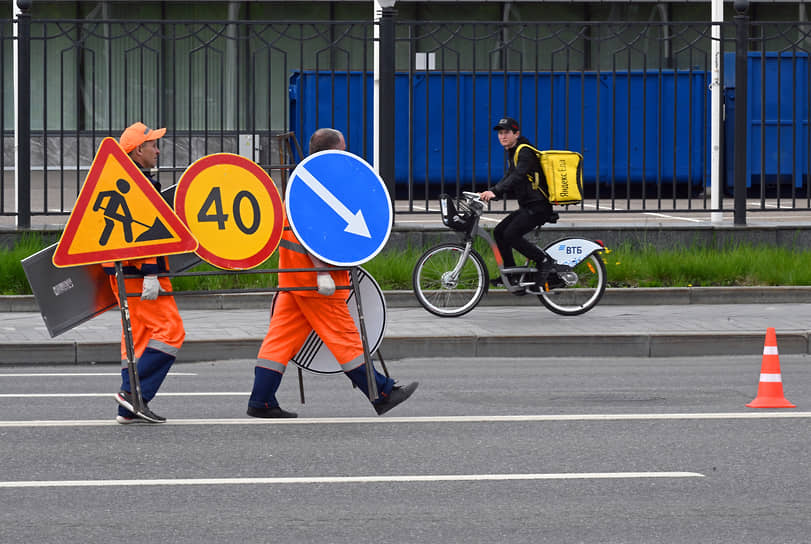 Москва. Рабочие переносят дорожные знаки