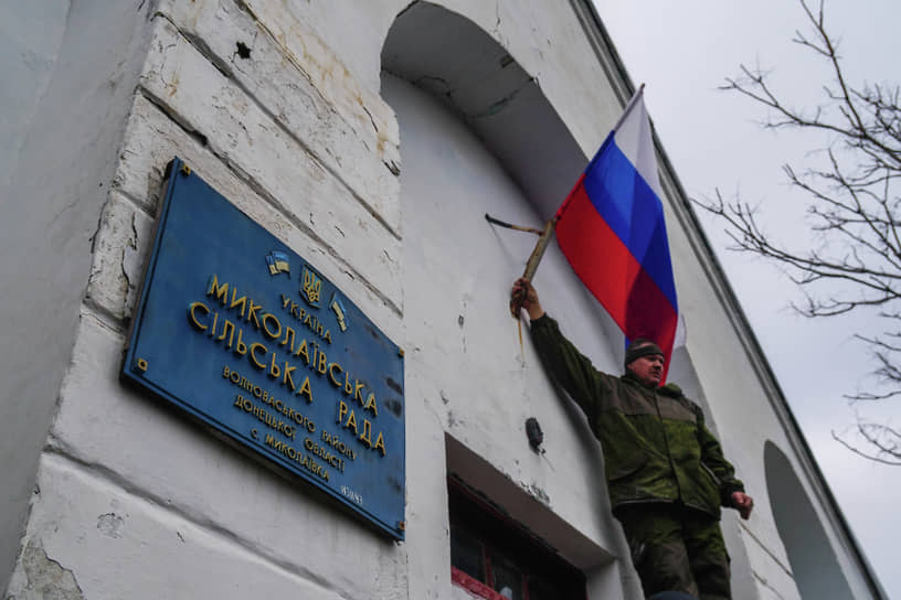 Военнослужащие водружают флаг России на здании администрации села Николаевка в ДНР