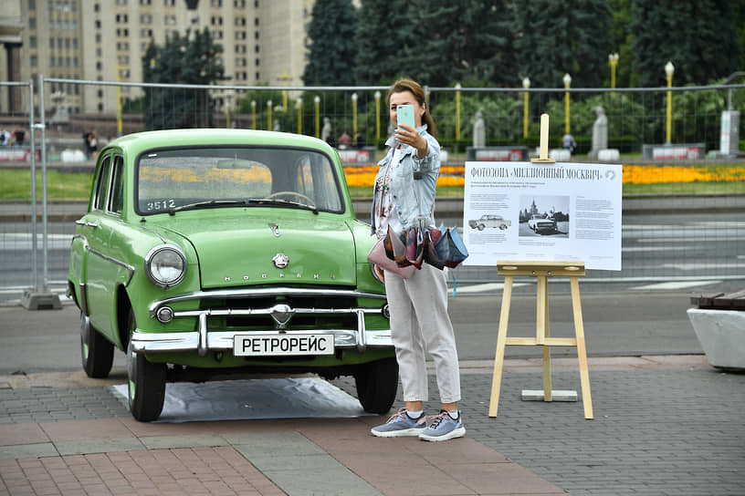 Посетительница выставки ретроавтомобилей возле «Москвич-407»