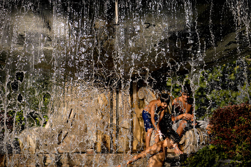 Бухарест. Дети играют в городском фонтане