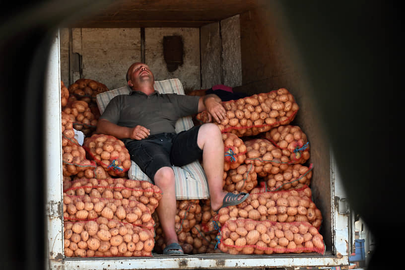 Мужчина в фургоне с картошкой на рынке