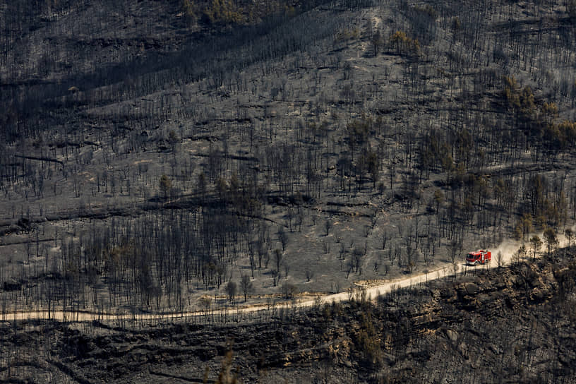 Пожарная машина едет через выгоревшие леса в Эль-Пон-де-Виломара к северу от Барселоны