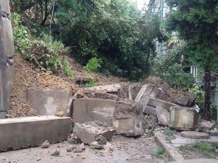 Разрушенная подпорная стена на улице Цюрупы. По данным властей города, стена придавила семь легковых автомобилей, но люди не пострадали