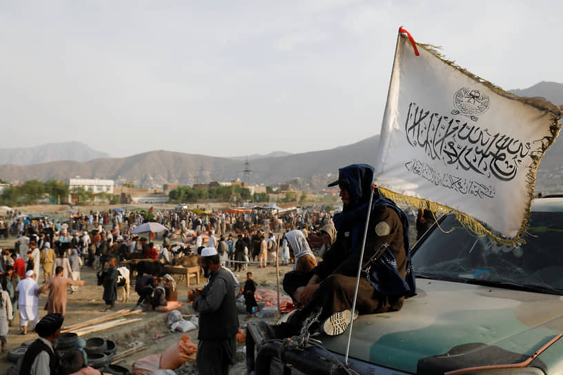 Сторонник талибов перед рынком в Кабуле