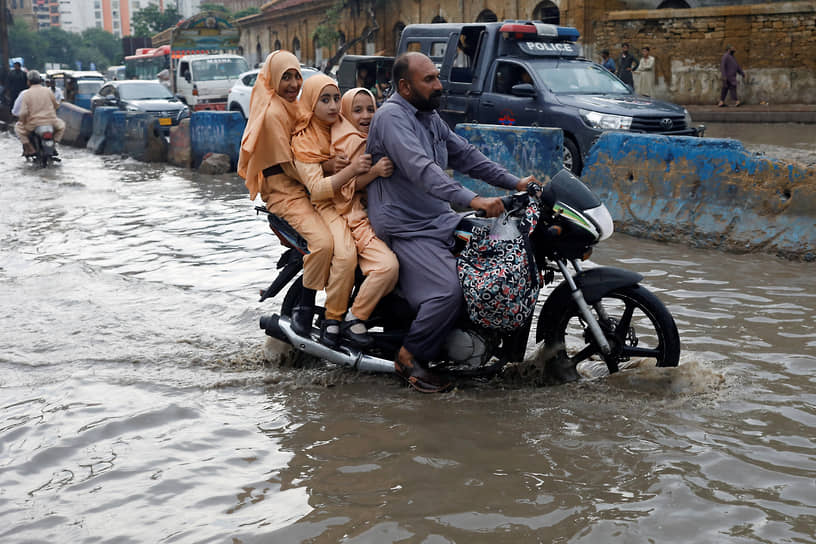 Карачи, Пакистан. Жители города едут по затопленной из-за дождей дороге