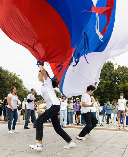 Молодые люди с триколором на праздновании Дня флага России в Калининграде 