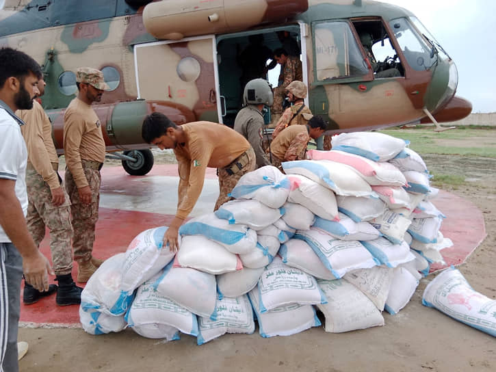Солдаты загружают гуманитарную помощь в вертолет во время операции по оказанию помощи в округе Сават