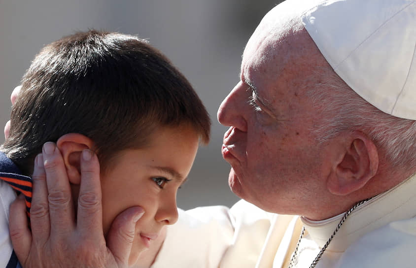 Ватикан. Папа римский Франциск целует ребенка в лоб на еженедельной общей аудиенции
