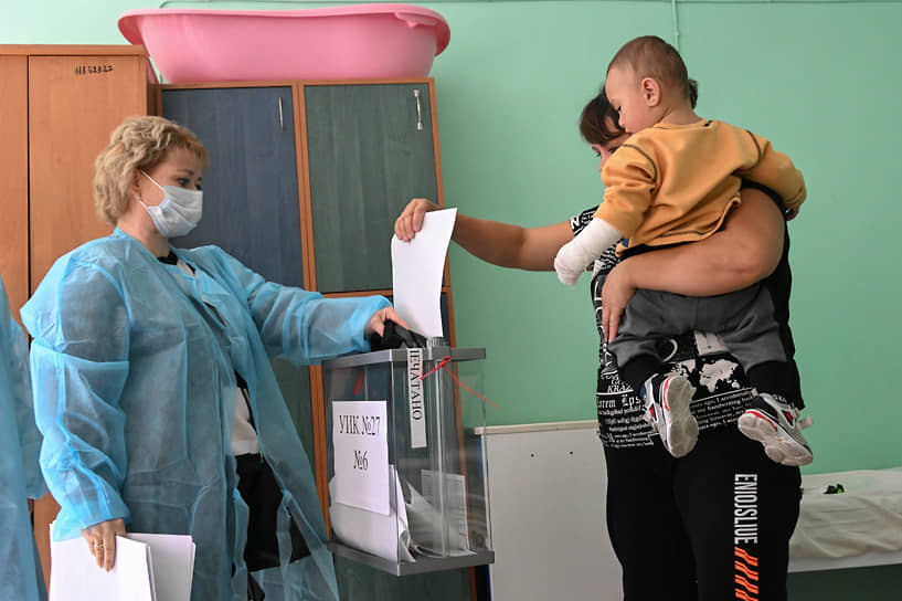 Сотрудники участковой комиссии и избиратели — пациенты больницы во время выездного голосования в ДНР