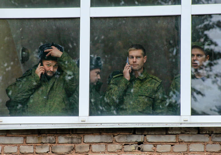 Мобилизованные разговаривают по телефону у окна в одной из воинских частей Ленобласти
