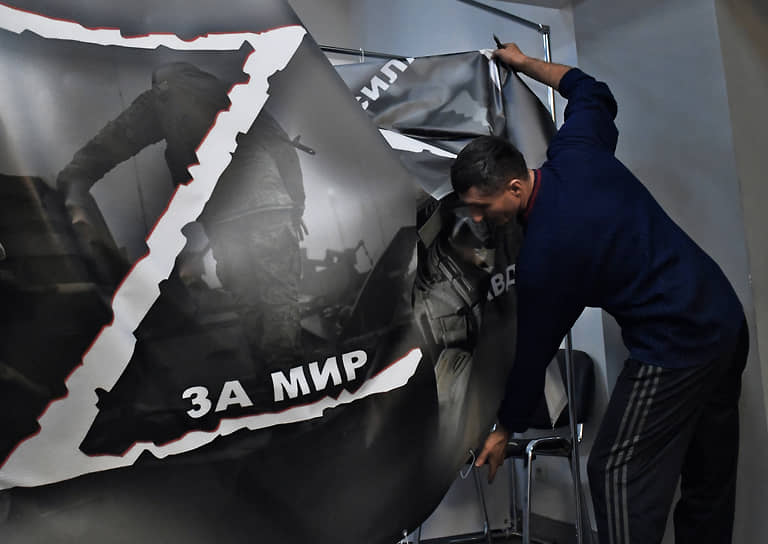 Мужчина снимает баннер с надписью «За мир» после закрытия временного пункта мобилизации в Театре Романа Виктюка в Москве