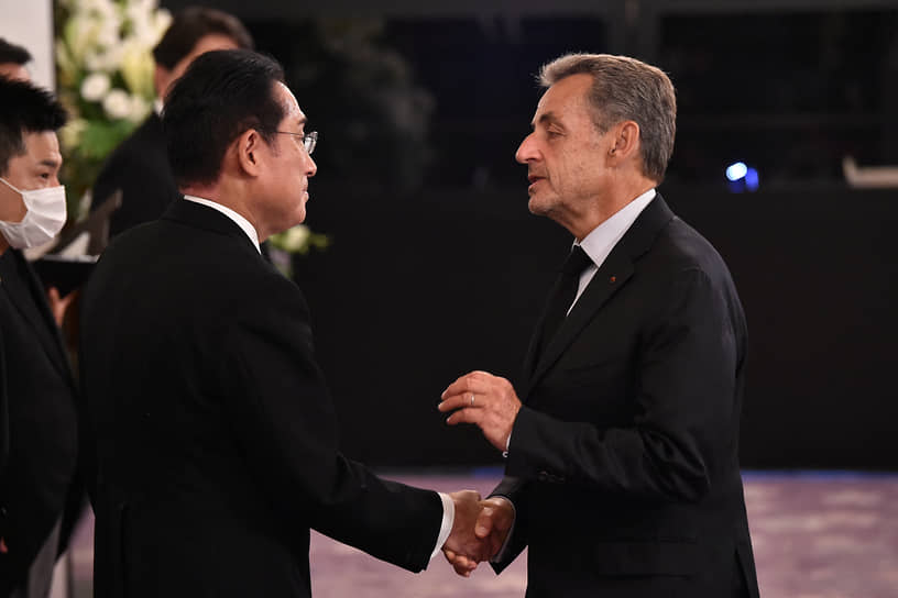 Премьер-министр Японии Фумио Кисида (слева) приветствует бывшего президента Франции Николя Саркози (справа) перед траурным приемом