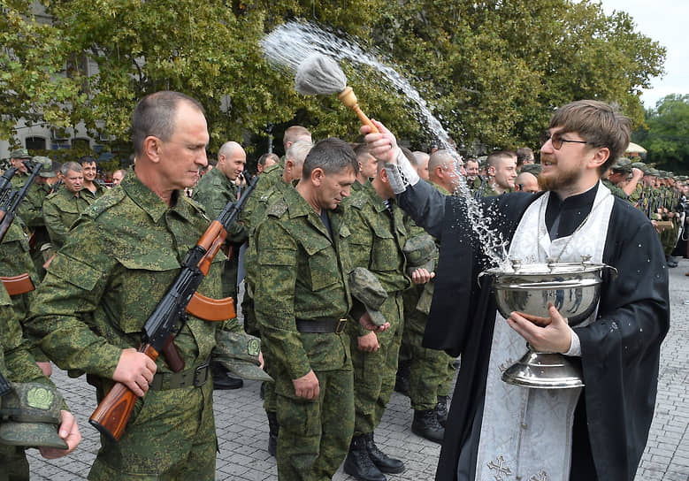 Севастополь, Россия. Священник окропляет мобилизованных мужчин на площади Нахимова