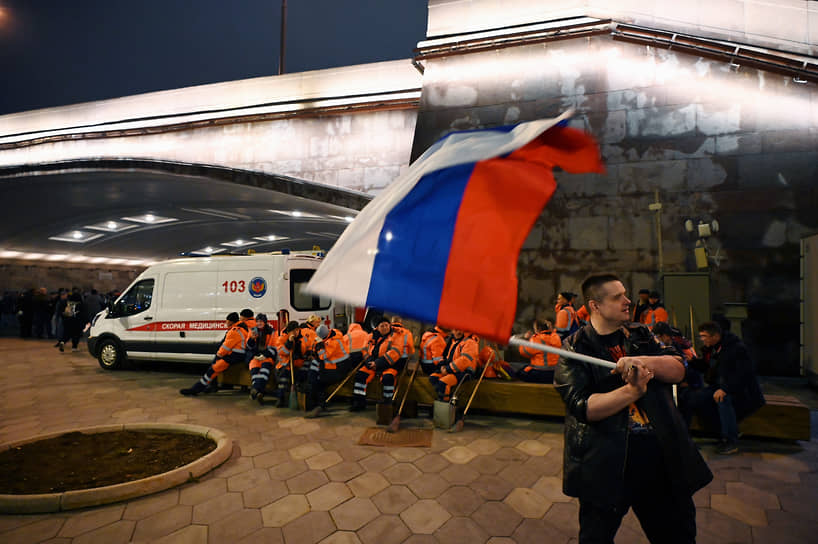 Участник митинга-концерта в Москве с российским флагом