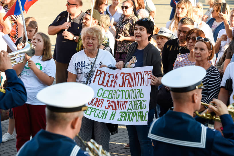 Жительницы Севастополя держат плакат в поддержку присоединения новых территорий