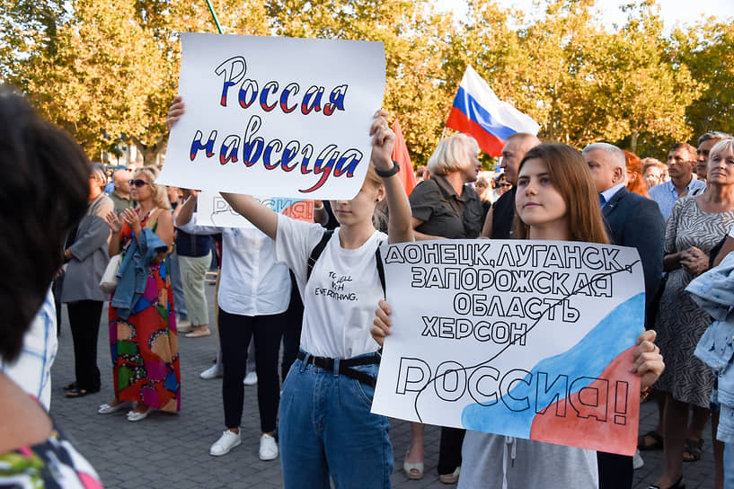 Участники митинга-концерта с плакатами в поддержку вхождения ДНР, ЛНР, Херсонской и Запорожской областей в состав России на площади Нахимова в Севастополе