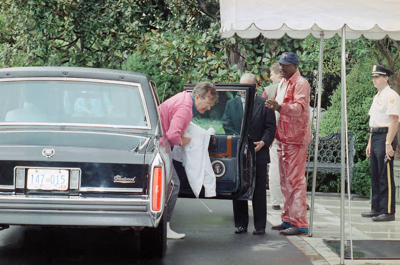 Президент США Джордж Буш выходит из машины Cadillac после игры в гольф на базе ВВС Эндрюс в Мэриленде, 1990 год