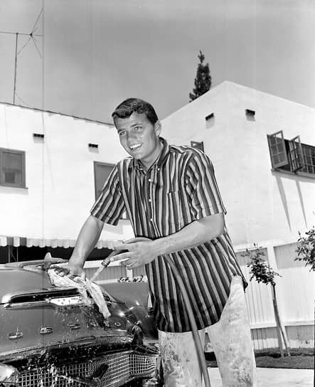 Пэт Уэйн, сын актера Джона Уэйна, моет машину марки Cadillac в доме своей матери Жозефины, 1956 год