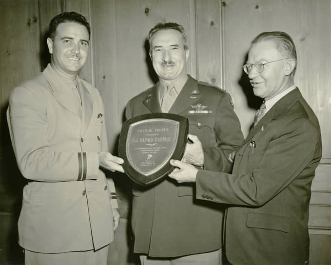 Полковник Харольд Харрис (в центре) получает памятный знак компании Switlik Parachute — через 11 лет после своего вошедшего в историю прыжка