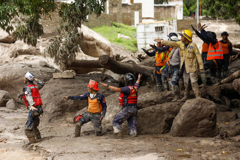 Члены спасательной команды работают в районе Лос-Кастанос в Маракае