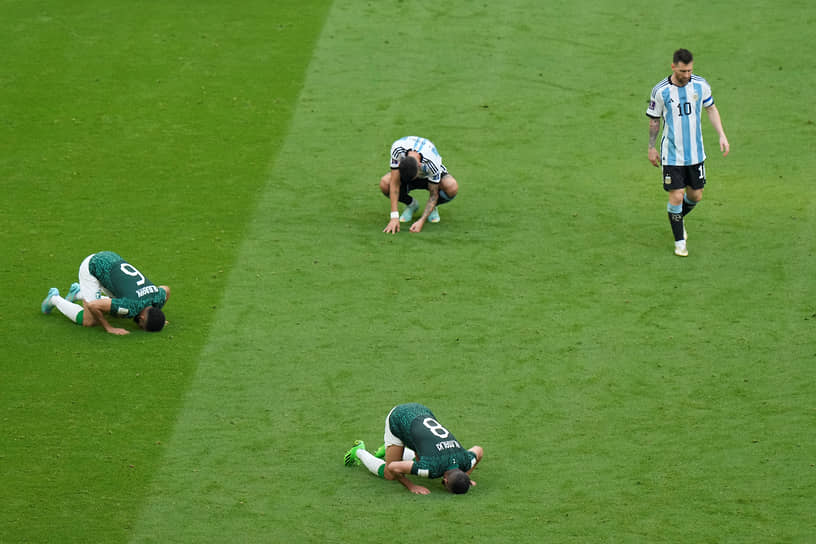 Нападающий Аргентины Лионель Месси (справа) покидает поле, пока футболисты Саудовской Аравии празднуют победу в матче