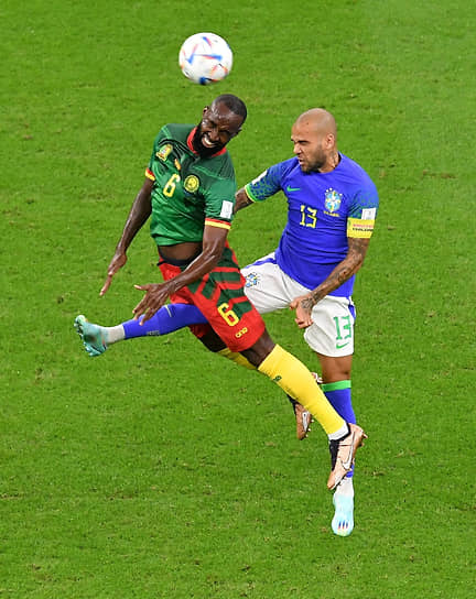 Защитник сборной Бразилии Дани Алвес борется за мяч с игроком команды Камеруна Николя Муми Нгамалё
