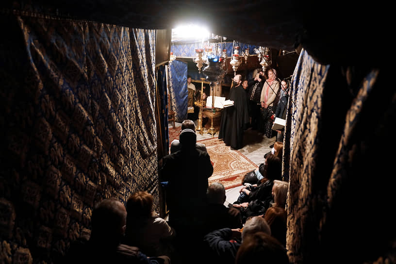 Верующие в гроте под храмом Рождества Христова в Вифлееме (Западный берег реки Иордан), который считается местом рождения Иисуса Христа