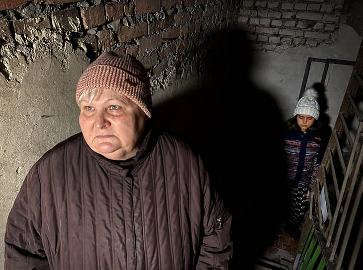 Жители Донецка осматривают разрушенный чердак многоэтажного дома, пострадавшего от обстрела