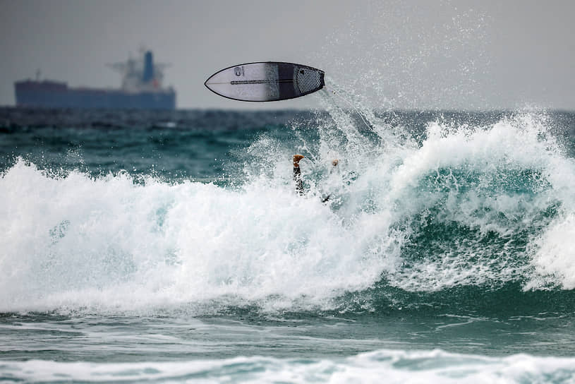 Ашкелон, Израиль. Доска для серфинга взмывает надо волнами Средиземного моря