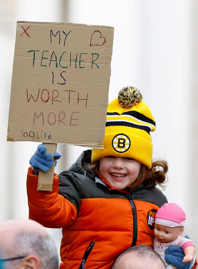 Ребенок из города Лутон держит плакат с надписью «Мой учитель стоит больше» 