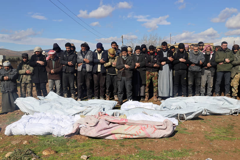 Местные жители молятся во время похорон жертв землетрясения в Джандарисе (Сирия)