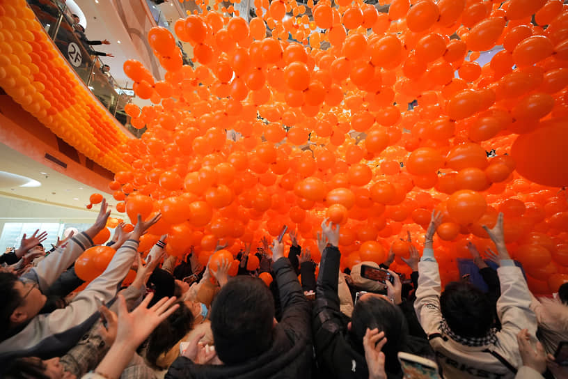 Яньтай, Китай. Посетители торгового центра ловят праздничные шары 